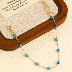 Close-up of golden stainless steel anklet with vibrant turquoise blue beads