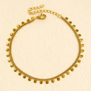 Detailed view of a gold stainless steel anklet with dangling round disk charms