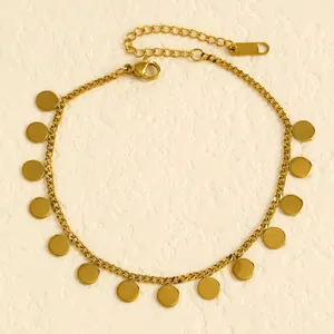 Close-up of gold stainless steel anklet featuring multiple round disc charms