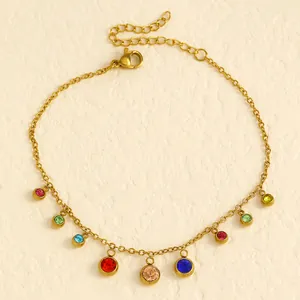 Detailed view of a gold stainless steel anklet with multi-color rhinestones on white texture