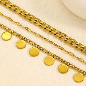 Close-up view of a gold stainless steel multi-layer anklet set featuring round disc charms