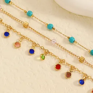Detailed view of colorful oil-drip charms on a golden stainless steel anklet set.
