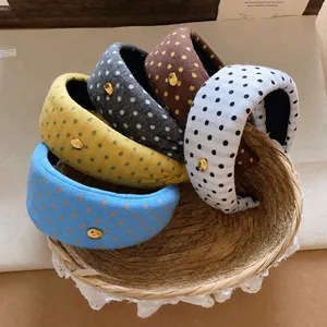 Fabric polka dot wide headbands set in five colors displayed in a rustic woven basket