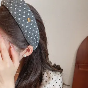 Side view of a gray polka dot wide fabric headband worn by a model for a stylish look