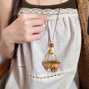 Detail of a vintage pastoral flower basket necklace with resin flowers on leather cord