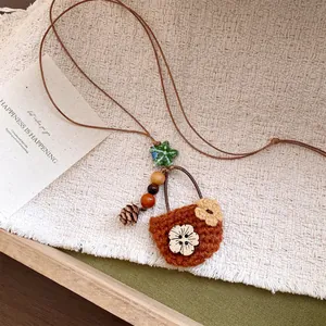 Close-up of vintage woven basket pendant necklace with wooden beads and pine cone charm