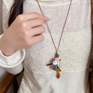 Detailed macro view of retro pastoral style flower basket pendant necklace on a knit sweater