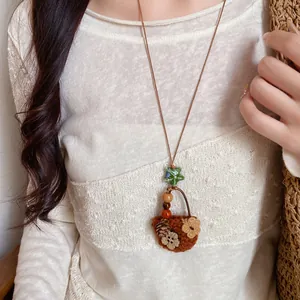 Detailed close-up of a retro pastoral flower basket pendant necklace on leather cord
