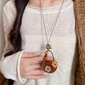 Detailed macro view of a vintage pastoral style knitted flower basket pendant necklace