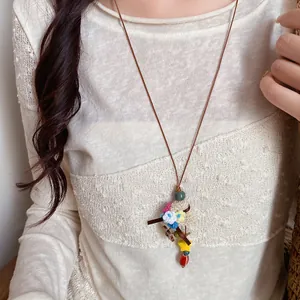Detailed view of a handmade crochet flower basket pendant on a vintage leather cord necklace.