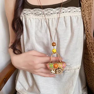 Detailed view of handmade woven basket pendant necklace with colorful floral charms