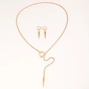 Detailed view of gold punk gothic necklace and spike earring set on white background