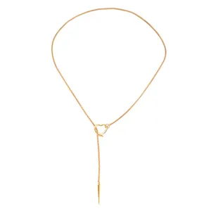 Close-up of a gold gothic lariat necklace with heart slider and rivet spike pendant.