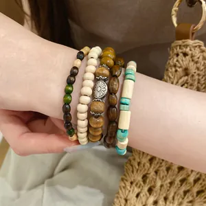 Detailed view of bohemian bracelet set featuring wood, stone beads and floral charm