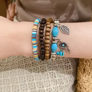 Close-up of bohemian beaded bracelet set with wood beads and leaf charm on a wrist