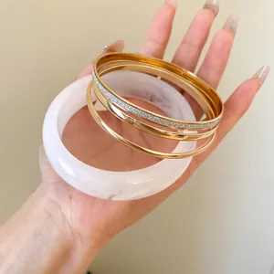 Detailed close-up of a stylish five-piece resin and gold-tone metal stacking bangle set