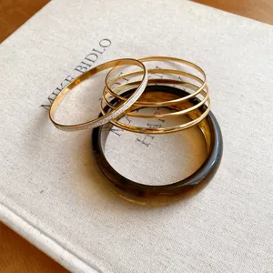 Close-up of resin and gold-plated metal bracelet set with glitter details