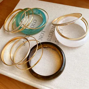 Close-up of resin and metal bangle set on a textured vintage book.