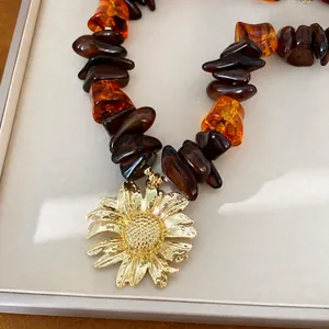 Elegante collana di perle in resina con un grande ciondolo a girasole dorato per donna