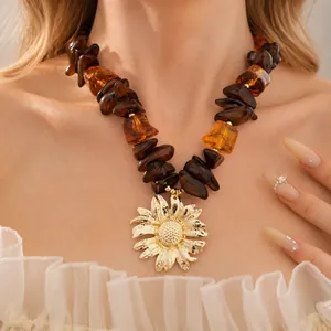 Collana con perle in resina e grande pendente a girasole dorato su una modella
