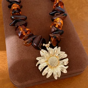Elegante collana di perle in resina ambrata con grande ciondolo a girasole dorato