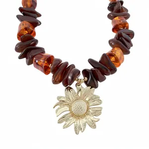 Collana di perle in resina con grande ciondolo a girasole dorato e pietre ambrate