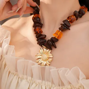 Primo piano di una collana di perline in resina con ciondolo a girasole