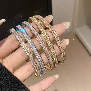 Close-up van elegante dubbelrijige strass armbanden in goud-, zilver- en roségoud.