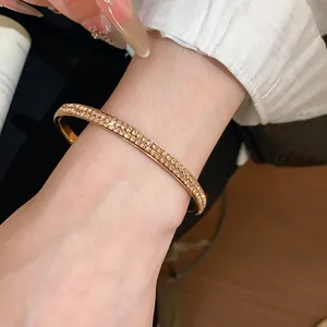 Close-up van een elegante roségouden armband met twee rijen kristallen om de pols