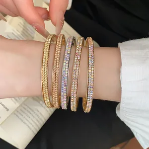 Detailweergave van vijf dubbelrijige kristallen armbanden in verschillende goudtinten