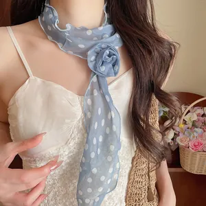 Detailansicht eines blau gepunkteten Chiffon-Schals mit Blumendekoration für Damen