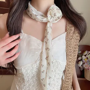 Nahaufnahme eines Chiffon-Schals mit Blumenmuster und einem dekorativen Blumenknoten