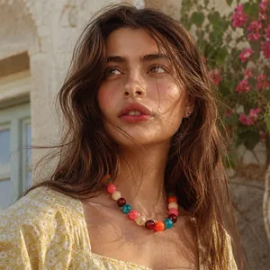 Collana bohémien fatta a mano con perle colorate indossata da una modella all'aperto
