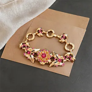 Detailed view of vintage gold flower bracelet featuring sparkling pink rhinestone accents
