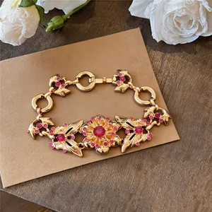 Detailed view of a vintage gold flower bracelet with pink rhinestones on kraft paper.