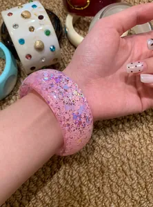 Macro view of a pink translucent acrylic bangle with shimmering heart-shaped glitter