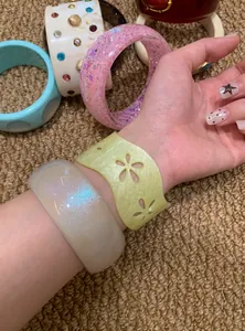Detailed view of colorful retro acrylic bangles worn on a wrist for a vintage style look.