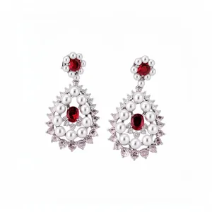 Elegant silver drop earrings with red gemstones and white pearls on a white background.