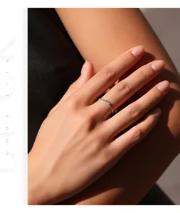 Detalle de un anillo trenzado minimalista de plata de ley 925 con moissanita brillante.