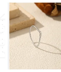 Detalle de un anillo de plata de ley 925 trenzado con tres piedras de moissanita