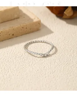 Detalle de un anillo de plata de ley 925 con banda trenzada y piedras moissanita