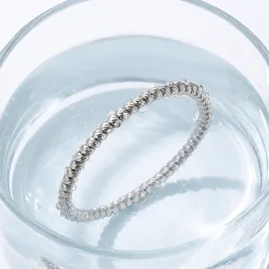 Detail view of a waterproof twisted rope design silver stainless steel bangle in water
