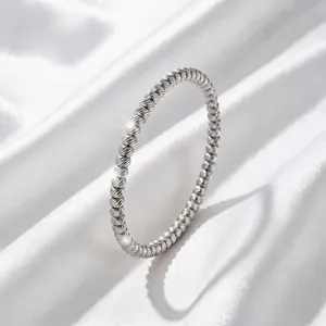 Detailed macro view of silver titanium steel twisted bangle featuring vacuum plating finish