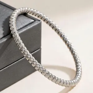Macro detail of elegant silver-tone twisted rope bangle bracelet displayed on a jewelry box