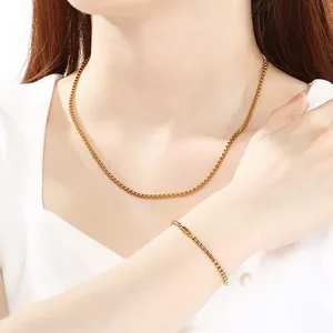 Model wearing gold-plated stainless steel box chain necklace and bracelet set