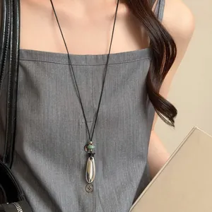 Elegante collana minimalista con ciondolo ovale in resina e perla verde su cordino nero