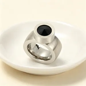 Gros plan d'une bague en acier brossé avec une grande pierre précieuse noire ronde