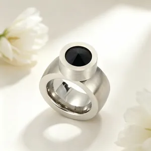 Gros plan détaillé d'une bague large en argent avec une pierre noire à facettes ronde.