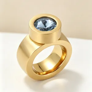 Vue détaillée d'une bague large dorée brossée avec une pierre précieuse bleu clair