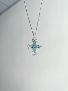 Détail du collier pendentif croix en argent avec des pierres de zircone vert menthe